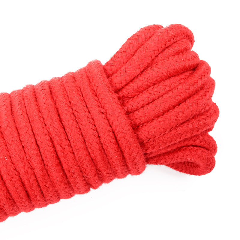 Red rope tied up showing a close up of the rope texture. On a white background 