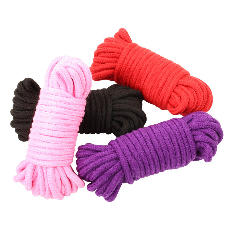 A pile of 4 ropes tied up and in a pile.Red, black, pink, purple. On a white background 